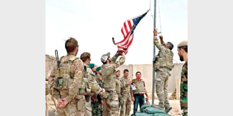 The US flag is taken down as troops hand over a military base to Afghan soldiers