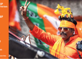A BJP supporter poses a victory sign during the celebration as the party leads in Uttar Pradesh Assembly elections