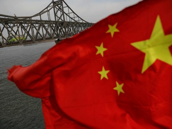 A Chinese flag is seen in front of the Friendship bridge over the Yalu River connecting the North Korean town of Sinuiju and Dandong in China's Liaoning Province  (Photo Source: REUTERS/Damir Sagolj)