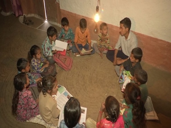 Children studying under light in Saddal (Photo Source: ANI)