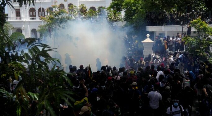 Police use teargas as Sri Lankan protesters storm prime minister Ranil Wickremesinghe 's office, demanding he resign after president Gotabaya Rajapaksa fled amid economic crisis in Colombo, Sri Lanka, Wednesday, July 13, 2022. (AP Photo/Rafiq Maqbool)