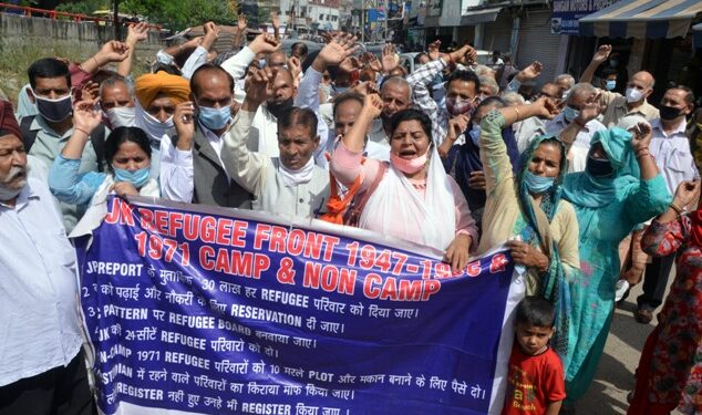 Refugees from PoJK and their supporters hold a banner and shout slogans during their protest over various demands in Jammu on March 30, 2021. (ANI Photo)