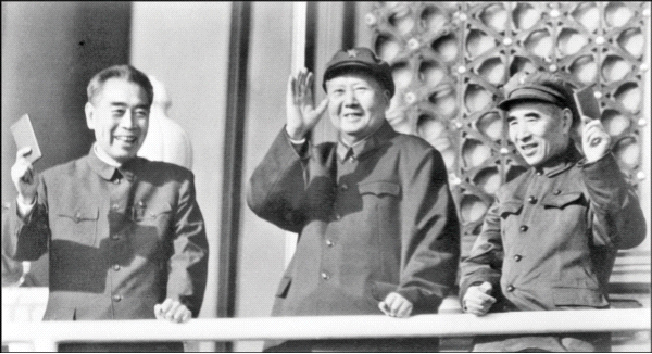 Top Chinese Communist Party leaders Premier Zhou Enlai (from left), Chairman Mao Zedong and Defense Minister Lin Piao hold up "Little Red Books" during a review of troops in Beijing's Tiananmen Square in October 1967