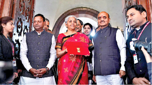 Union Finance Minister Nirmala Sitharaman, along with MOS Bhagwat Kishanrao Karad and Pankaj Chaudhary, holds up a folder with the Government of India’s logo before leaving  her office to present the  Budget in the Parliament on February 1, 2023