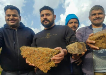 Residents of Salal village pose for photos showing lithium stones, in Reasi District on February 11, 2023