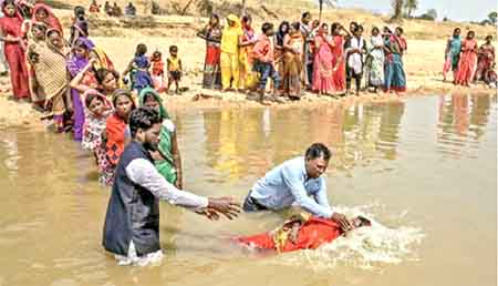 Villagers being baptised on the banks of a river in Bihar