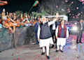 Prime Minister Narendra Modi waves at BJP workers as party President J P Nadda looks on during celebrations at the BJP HQ in New Delhi