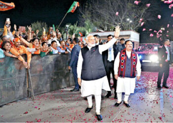 Prime Minister Narendra Modi waves at BJP workers as party President J P Nadda looks on during celebrations at the BJP HQ in New Delhi