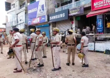 Police personnel stand guard at an area in Nuh