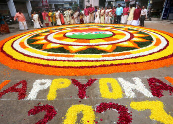 Malayali community members decorate 'Pookalam', a rangoli made with fresh flowers, as part of the celebration of Onam festival