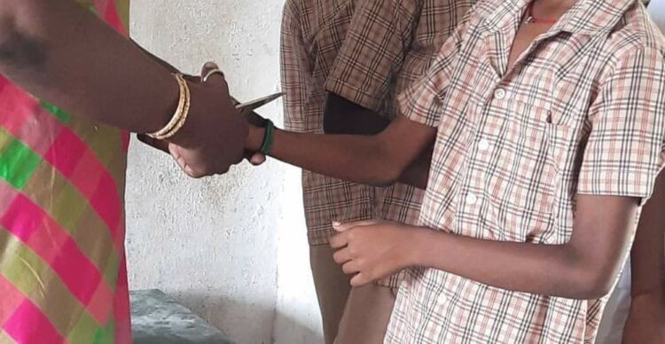 Teacher cutting the sacred thread off a Hindu student's hand in Tamil Nadu (Facebook)
