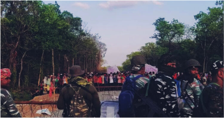 A section of villagers protesting against the security camp while the security forces guard the barrier in Silger of Bastar division in Chhattisgarh