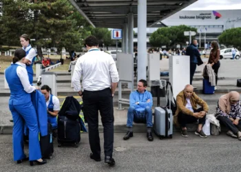 Passengers and airline staff wait outside Toulouse-Blagnac Airport in southwestern France on October 18, 2023, after the airport was evacuated.