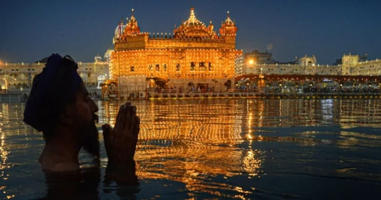 Devotee taking holy dip Amrit Kund at Golden Temple in Amritsar