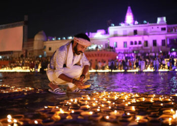 A man lights an earthen lamp during Deepotsav celebrations in Ayodhya last year