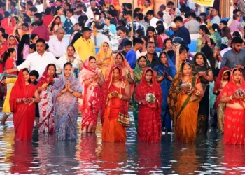 Devotees offer prayers to the setting sun on the banks of the river Brahmaputra