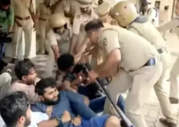 Police remove protestors at the Calicut University