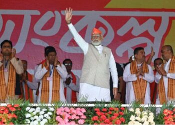 Prime Minister Narendra Modi waves to the gathering during a public meeting at Krishnanagar in Nadia. West Bengal Opposition leader Suvendu Adhikari and state BJP President Sukanta Majumdar also seen