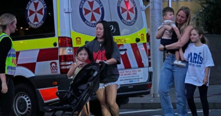 People are led out from the Westfield Shopping Centre where multiple people were stabbed in Sydney. Picture: AP Photo/Rick Rycroft