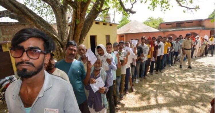 Voters standing in  queue  to cast their votes