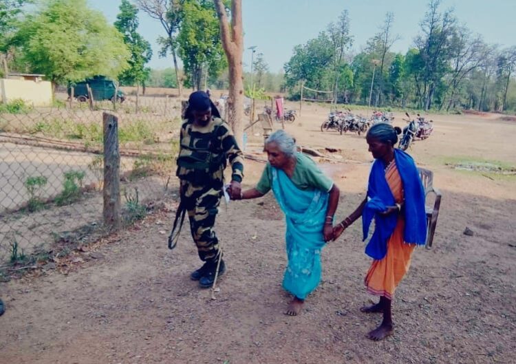 A security personnel assisting an elderly lady to a polling station in Bastar : Curtsey ECI