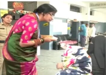 BJP candidate Madhavi Latha checking the voter id of the electorate