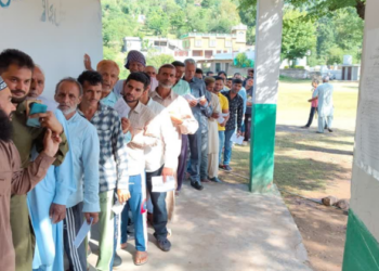 Voters standing in a queue to exercise their right to vote at a polling station in Anantnag