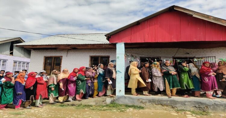 People stand in line to vote at a polling station during the fourth general election phase, in south Kashmir’s Pulwama district