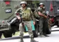 Armed security personnel standing in front of the vehicle