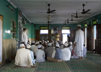 A representative image showing Muslim men gathered at a hall