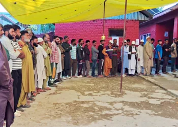 Jammu and Kashmir, Oct 01 (ANI): Voters wait in a queue to cast their votes for the third and final phase of Jammu and Kashmir Assembly elections, on Tuesday. (ANI Photo)