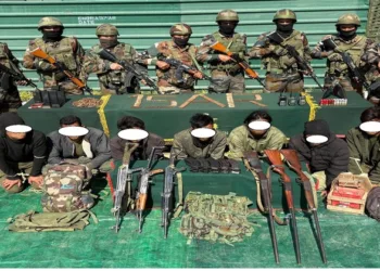 Security forces with arrested Kuki militants and seized arms