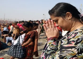 A woman devotee worshipping at Triveni Sangam at Mahakumbh