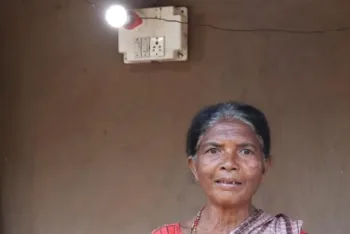 A villager standing at the front of electric bulb in Timenar village, image courtesy Chhattisgarh dpr