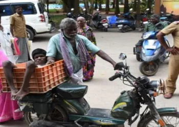 Disabled boy's parents carrying him in a bin. (Image Credit: Dinamalar Tamil Daily)