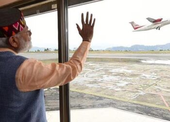 Prime Minister Narendra Modi waving at an aircraft