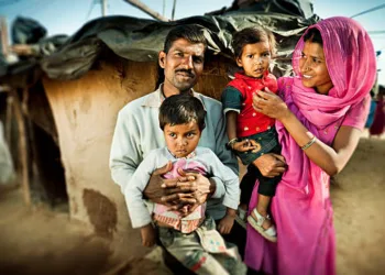 Happy parents with their children near their adobe house in slum colony of village (Image used for representative purposes, source: iStock)