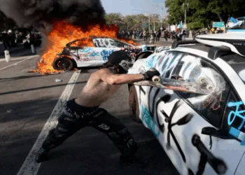 A man damages the vehicle in Los Angeles (Images Source: Los Angeles Times )