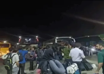 Kashmiri students evacuated from Iran waiting to board the bus
