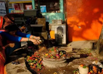 Devotees offering bela patri and water to the Shivlinga on the ocasion of Shravan month as they worship Bhagwan Shiva