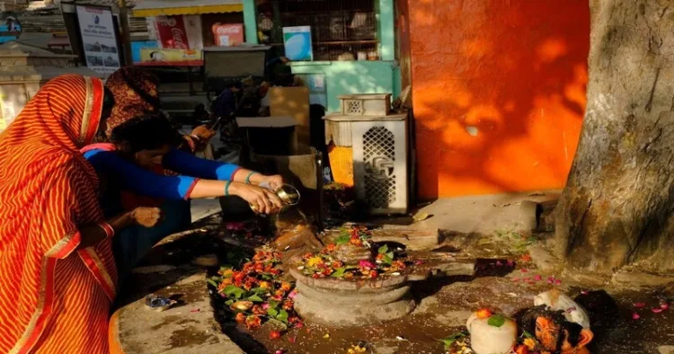 Devotees offering bela patri and water to the Shivlinga on the ocasion of Shravan month as they worship Bhagwan Shiva
