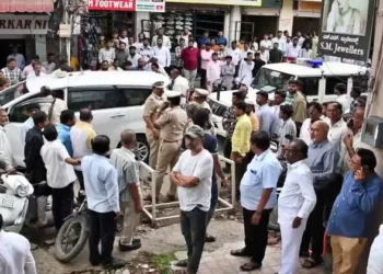 Police and locals gather outside the gold shop in Kalaburagi where the robbery took place