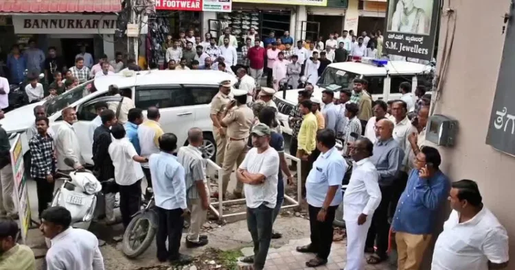 Police and locals gather outside the gold shop in Kalaburagi where the robbery took place