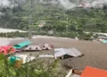Damaged structures and muddy landscape in Uttarkashi after the cloudburst and flash floods demonstrate the disaster's impact and need for coordinated rescue efforts