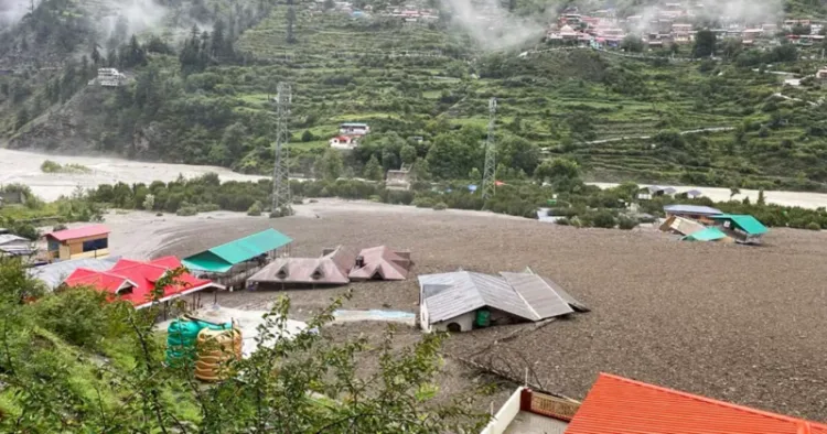 Damaged structures and muddy landscape in Uttarkashi after the cloudburst and flash floods demonstrate the disaster's impact and need for coordinated rescue efforts