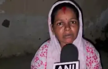 Minta Devi from Bihar's Siwan reacts to her name and face printed on shirts worn by opposition leaders during a protest in New Delhi on August 12. (Image: ANI)