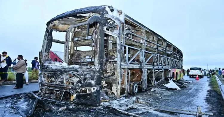 Charred remains of a passenger bus lie on a highway in Chinnatekuru village, where it caught fire early Friday after a collision with a motorbike, near Kurnool district