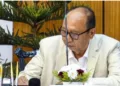 BJP legislator Yumnam Khemchand Singh signs during his swearing-in as new Manipur Chief Minister, in Imphal