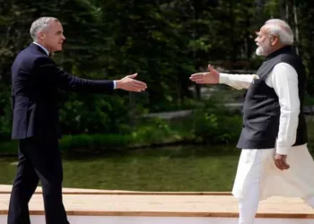 Prime Minister Narendra Modi and Canada's Prime Minister Mark Carney reach to shake hands at the G7 Summit in Kananaskis, Alberta