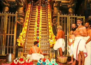 Priests conduct the sacred Padi Puja at the revered 18 Holy Steps of Sabarimala, adorned with flowers and lamps, during the auspicious Mandala–Makaravilaku season.